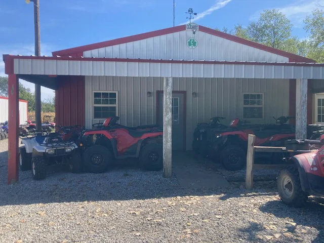 ATVs parked beneath the covered front of the Olive Creek ATV shop